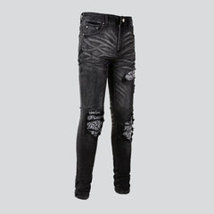 Schwarze zerrissene Vintage-Bikerjeans