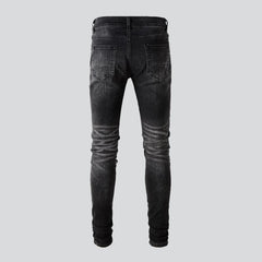 Schwarze zerrissene Vintage-Bikerjeans