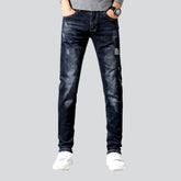 Leicht zerrissene schwarze Herrenjeans