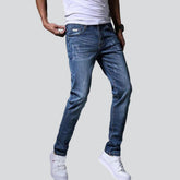 Leicht zerrissene blaue Herrenjeans