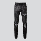 Schwarze zerrissene Vintage-Bikerjeans