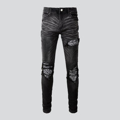 Schwarze zerrissene Vintage-Bikerjeans