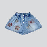 Breite, mit Blumen verzierte Jeansshorts