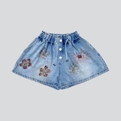 Breite, mit Blumen verzierte Jeansshorts