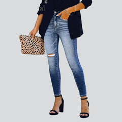 Vaqueros ajustados de mujer con pierna rasgada