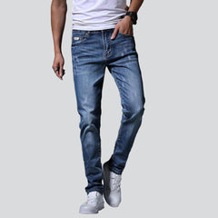 Vaqueros de hombre azules ligeramente rotos