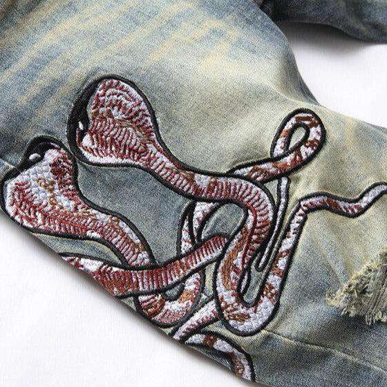 Zerrissene Herrenjeans mit Cobra-Stickerei