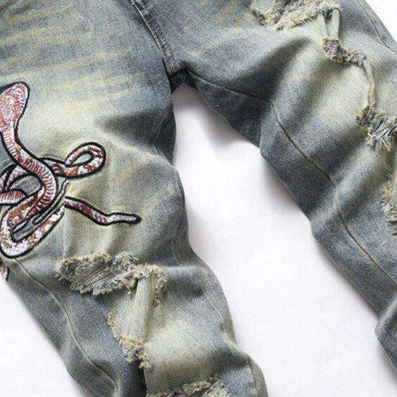 Zerrissene Herrenjeans mit Cobra-Stickerei